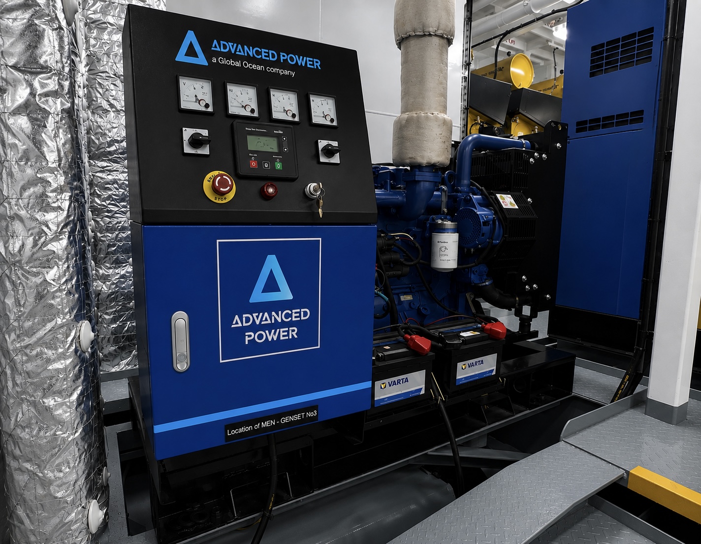 An Advanced Power genset control panel with analogue meters, a digital controller and emergency stop beside a marine diesel engine